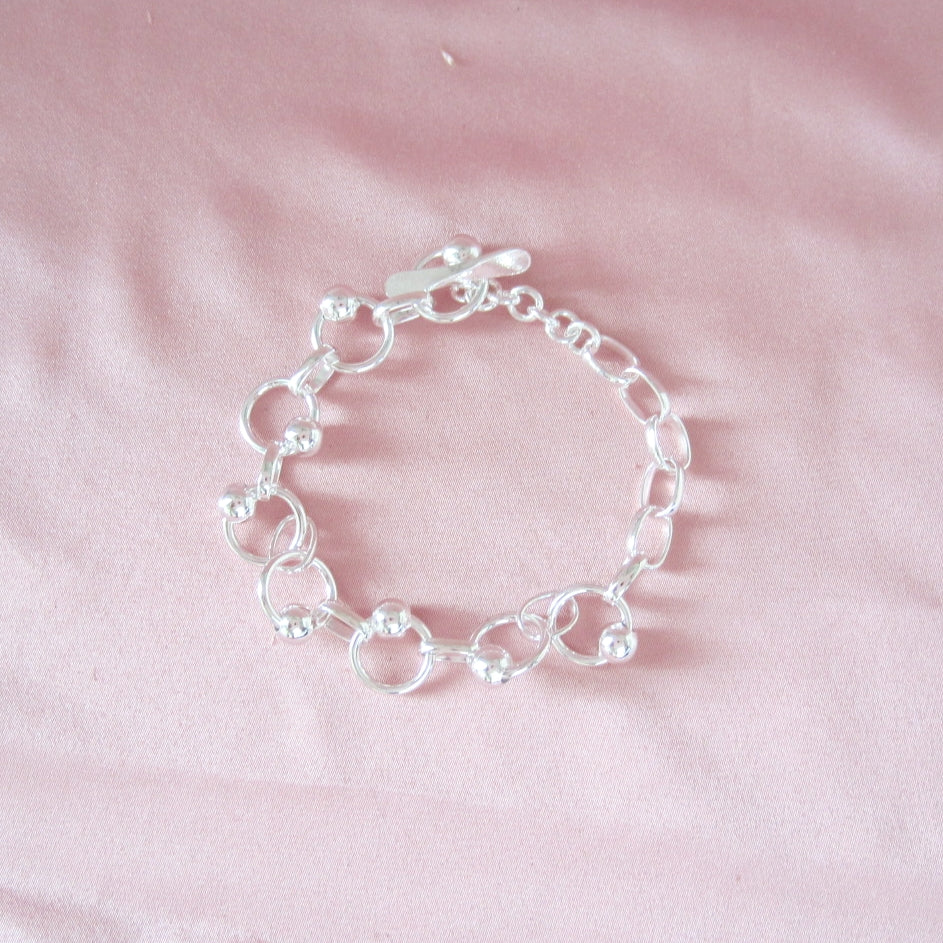 Pulsera Plateada Aritos y Bolitas