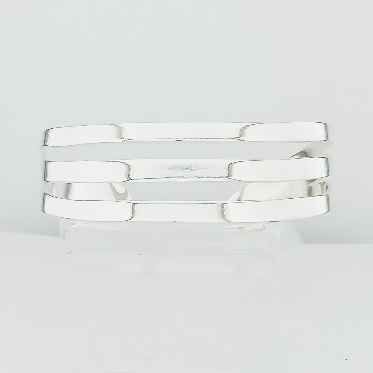 Brazalete plateado lineal curvo